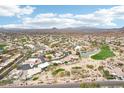 Expansive aerial view of a desert community with mountain views, golf course, and blue skies at 6460 E Trailridge Cir # 2, Mesa, AZ 85215