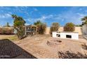 Backyard featuring a brick fire pit, chicken coop, and mature landscaping at 7458 E Clovis Cir, Mesa, AZ 85208