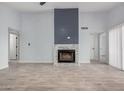 Bright, airy living room featuring a fireplace with stone accents and light wood-look flooring at 8826 W Amelia Ave, Phoenix, AZ 85037