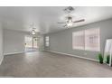 Bright living room with wood-look floors, neutral paint, ceiling fans, and backyard access at 9734 W Carol Ave, Peoria, AZ 85345