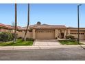 Charming home with a well-manicured lawn, a two-car garage, and a beautiful desert landscape at 10243 N 103Rd St, Scottsdale, AZ 85258