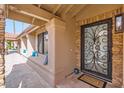 Inviting front porch featuring decorative stonework, decorative security door, and a cozy sitting area at 10243 N 103Rd St, Scottsdale, AZ 85258