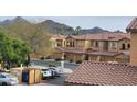 View of multi-story townhomes with desert landscaping, car parking, and mountain views at 10655 N 9Th St # 204, Phoenix, AZ 85020