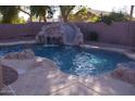 Inviting pool features rock waterfall, and a slide perfect for summer fun in the backyard at 1083 E Jade Dr, Chandler, AZ 85286