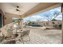 Relaxing covered patio with ceiling fan, lounge seating, and a beautiful view of the backyard pool area at 11122 N 165Th Ave, Surprise, AZ 85388