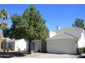 Pleasant single-story home featuring a large shade tree, a neutral color palette, and a gray-tiled roof at 1133 N Florence Dr, Chandler, AZ 85226