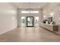 Bright foyer featuring a stone accent wall, modern light fixture, and wood-look flooring at 12240 N 62Nd Pl, Scottsdale, AZ 85254