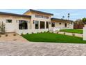 Contemporary home with a stone accent wall, lush green lawn, and modern landscaping at 12240 N 62Nd Pl, Scottsdale, AZ 85254