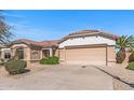 Charming single-story home featuring a tile roof, desert landscaping, and a two-car garage, all under a clear sky at 14314 W Pecos Ln, Sun City West, AZ 85375