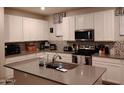 Spacious kitchen featuring white cabinets, stainless steel appliances, and a gray island countertop at 16648 W Jenan Dr, Surprise, AZ 85388