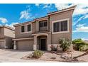 Attractive tan two story home with well-manicured desert landscaping and a spacious two car garage at 1735 W Wildwood Dr, Phoenix, AZ 85045