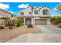 Inviting two-story house featuring neutral tones, a covered entrance, and well-maintained landscaping at 17771 W Caribbean Ln, Surprise, AZ 85388