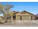 Charming front exterior showcasing a well-maintained lawn and a spacious three-car garage and neutral colored exterior at 18097 W Santa Alberta Ln, Goodyear, AZ 85338