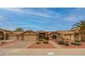 Welcoming single-story home with neat desert landscaping, a two-car garage, and a brick-paved driveway at 18730 N 89Th Ave, Peoria, AZ 85382