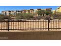 Property backing up to desert landscape, with views of modern buildings beyond a fence at 21112 N 58Th St, Phoenix, AZ 85054