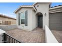 Inviting home facade with gray siding, shutters, brick-paved entrance and desert landscaping at 24267 W Gibson Ln, Buckeye, AZ 85326