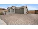 Beautiful home with a brick driveway and desert landscaping, showcasing its curb appeal at 24267 W Gibson Ln, Buckeye, AZ 85326