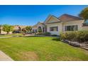 Well-maintained single-story home with a large, green front lawn and mature landscaping in a suburban setting at 2467 E Page Ave, Gilbert, AZ 85234