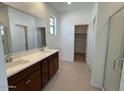 Bright bathroom with double sinks, granite countertops, and a glass enclosed shower at 25180 W Wayland Dr, Buckeye, AZ 85326