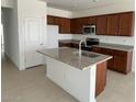 Modern kitchen featuring granite countertops, stainless steel appliances, and a large center island at 25180 W Wayland Dr, Buckeye, AZ 85326