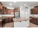 Kitchen with stainless steel refrigerator, kitchen island, dark cabinets, and tile floors at 29997 N 70Th Dr, Peoria, AZ 85383