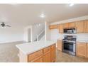 Bright kitchen featuring an island, stainless steel appliances and light wood cabinets at 35030 N Barzona Trl, San Tan Valley, AZ 85143