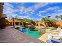 Relaxing pool area with a built-in spa, lounge chairs, and a covered patio for outdoor living and entertaining at 3768 N 162Nd Ln, Goodyear, AZ 85395