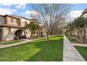 Attractive townhome community with manicured lawns and inviting walkways lined with trees and landscaping at 4251 N Golf Dr, Buckeye, AZ 85396