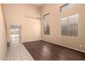 Neutral living room with dark wood flooring, high ceilings, and natural light from large windows at 4255 E Cloudburst Ct, Gilbert, AZ 85297