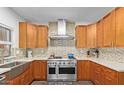 Bright kitchen featuring custom wood cabinets, stainless steel appliances, and mosaic tile backsplash at 45 E 9Th Pl # 12, Mesa, AZ 85201