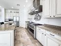 Spacious white kitchen with stainless steel appliances, a stone topped island, and lots of counter space at 6039 E Sienna Bouquet Pl, Cave Creek, AZ 85331