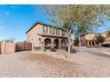 Charming two-story home with desert landscaping, featuring a gated entrance and inviting front porch with stone pillars at 6208 N 78Th Dr, Glendale, AZ 85303