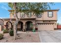 Charming two-story home featuring a two-car garage and inviting front porch with stone pillars and a decorative tree at 6208 N 78Th Dr, Glendale, AZ 85303