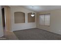 Bright living room features neutral walls, plush carpet, and elegant chandelier, creating a welcoming ambiance at 8014 W Beaubien Dr, Peoria, AZ 85382