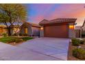 Charming single-Gathering home features a well-manicured lawn, neutral stucco, and a two-car garage at 9035 W Quail Track Dr, Peoria, AZ 85383