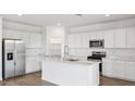 Modern kitchen with stainless steel appliances, white cabinets, an island, and a pantry at 9849 S Caballo Dr, Apache Junction, AZ 85120