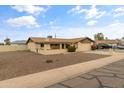 Expansive gravel front yard, covered patio, and xeriscaping define this single-story home's curb appeal at 2220 W Surrey Ave, Phoenix, AZ 85029