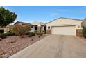 Lovely home exterior with desert landscaping and a long driveway leading to the garage at 3134 N 145Th Ave, Goodyear, AZ 85395