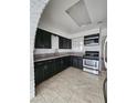 Cozy kitchen featuring dark cabinets, a stainless steel microwave and range, and tile flooring at 319 N 2Nd Ave, Avondale, AZ 85323