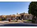 Tan home with a well-manicured front yard and a three car garage on a sunny day at 3631 S Greythorne S Way, Chandler, AZ 85248