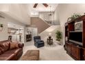 Spacious living room featuring soaring ceilings, a ceiling fan, and stairs to the upper level at 4122 E Jojoba Rd, Phoenix, AZ 85044