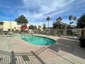 Community pool surrounded by lush landscaping and lounge chairs at 4620 N 68Th St # 117, Scottsdale, AZ 85251