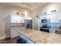 Bright, modern kitchen featuring white cabinets, granite countertops, stainless steel appliances, and an island with stool seating at 532 N 102Nd Pl, Mesa, AZ 85207