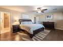 Spacious main bedroom featuring wood floors, ceiling fan, a large bed, and elegant furnishings at 532 N 102Nd Pl, Mesa, AZ 85207