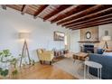 Inviting living room featuring wood beam ceiling, stone fireplace, and hardwood floors at 541 W Edgemont Ave, Phoenix, AZ 85003