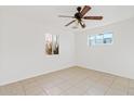 Bright bedroom with tiled floors, ceiling fan, and natural light from two windows at 724 S Lewis --, Mesa, AZ 85210