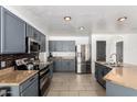 A remodeled kitchen featuring gray cabinets, stainless steel appliances and tiled floors at 8812 N 67Th Dr, Peoria, AZ 85345