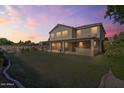 Spacious backyard featuring lush lawn, covered patio, and privacy landscaping at 9237 W Alex Ave, Peoria, AZ 85382