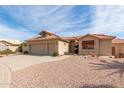 A well-maintained tan home with a tile roof and desert landscaping at 9519 E Indiana Ct, Sun Lakes, AZ 85248