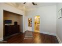 Bedroom with hardwood floors, a dresser, a tv and a view of the kitchen and bathroom at 9718 E Boston St, Mesa, AZ 85207